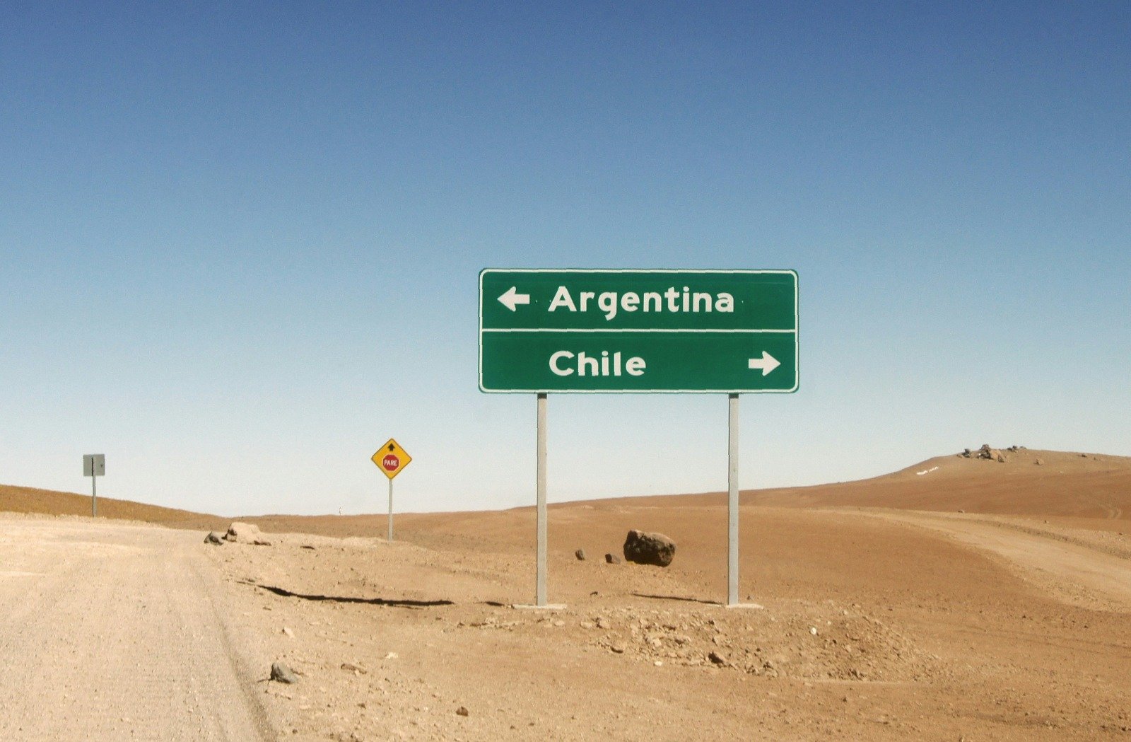 Road sign in the Andean desert pointing to Argentina and Chile